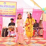 JYLD Ideal Inter College varshikotsav 2026 mein chhoti bachchiyan Radha Krishna ke vesh mein manch par natak prastuti dete hue dhol tabla sangat ke saath