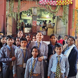 JYLD Ideal Inter College ke vidyarthi aur shikshika school uniform mein mandir dharmik sthal par educational tour ke dauran